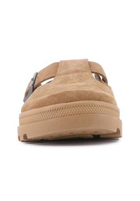 Sandali in suede beige con doppie cinghie, suola in gomma texturizzata e un accento in metallo sul lato per una vestibilità regolabile.