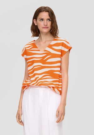 Oranje en crèmekleurige gestreepte blouse met een V-hals en kapmouwen, gemaakt van lichte stof, gecombineerd met witte linnen broek.