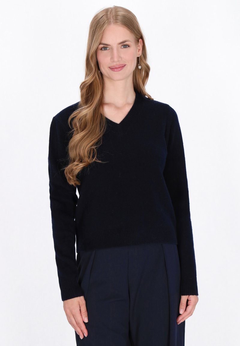 Maglione navy a V realizzato in materiale morbido, con maniche lunghe e design aderente, dalla tessitura liscia e senza motivi visibili.