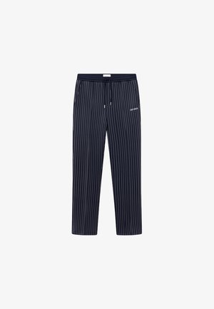 Pantalon bleu marine à fines rayures blanches verticales, taille élastique avec cordon, poches latérales, et petit logo "LES DEUX" sur la cuisse gauche.
