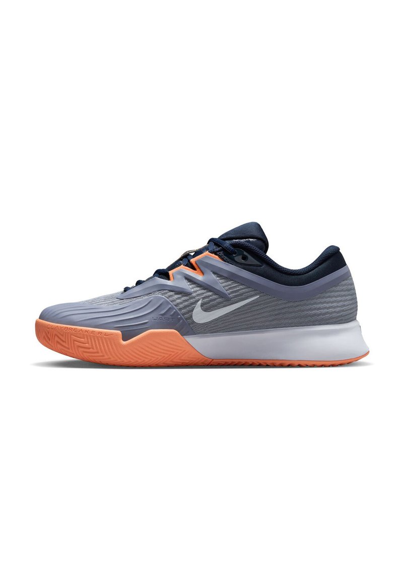 Nike sportska obuća z značilnim logotipom, s gornjim dijelom od sivog mrežastog materijala, narančastom gumiranom potplatnom, aerodinamičnim dizajnom i teksturiranim detaljima.