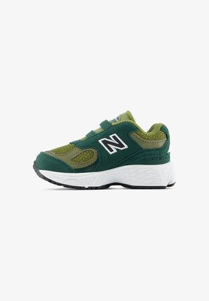 Grøn og olivengrøn New Balance sneaker med hvid sål, mesh og ruskind overdel og to velcrobånd, vist fra siden mod hvid baggrund.