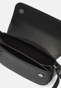 Czarna skórzana torebka na ramię o gładkiej fakturze, z zapięciem na zatrzask i wnętrzem z dwoma przegrodami. Regulowany pasek.