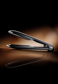 Schwarzer Haarglätter mit einem schlanken Design, abgerundeten Kanten und glatter Oberfläche, die Licht auf einer polierten Fläche reflektiert.