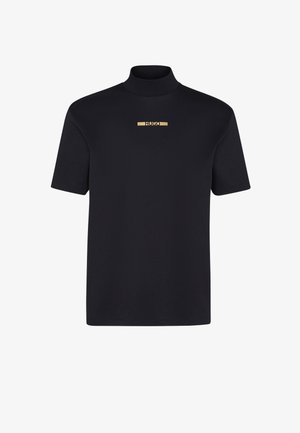 Černé tričko s krátkým rukávem a vysokým límcem, uprostřed zdobené zlatým logem. Vyrobeno z měkké, hladké látky. Jednoduchý design.