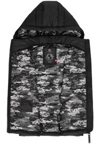 Giacca a vento nera con cappuccio. L'interno presenta un motivo di camouflage digitale grigio e nero, sezioni trapuntate e etichette di branding.