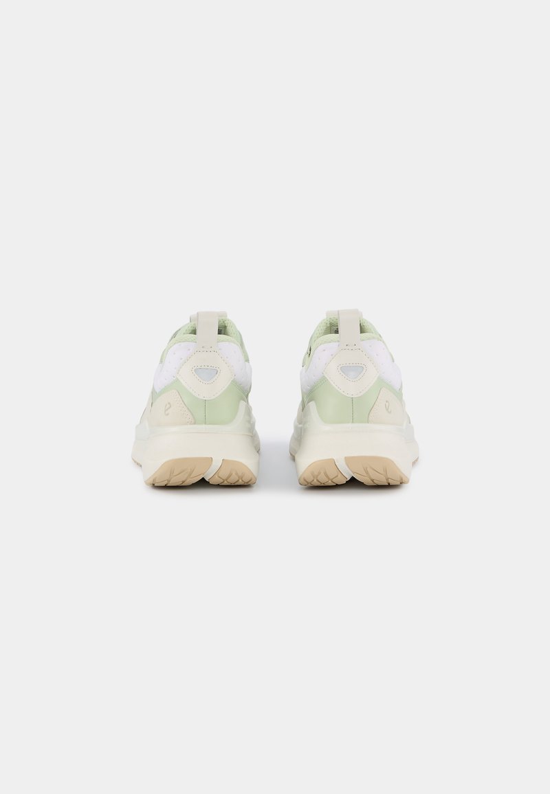 Grüne und beige Sneaker mit einer strukturierten Oberseite, gepolstertem Kragen und Ziehschlaufe. Weiße Akzente und gemusterte Sohle für besseren Grip.