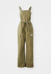 Olivenfarget jumpsuit med justerbare stropper, tettsittende bodice, bred ben silhuett, frontlommer og et knyttet belte i midjen.