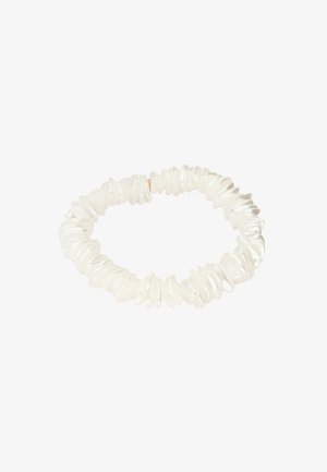 Bracelet extensible composé de perles blanches de forme irrégulière, disposées étroitement en un motif circulaire sur fond blanc.