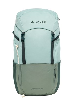 Himmelblau-grüner Rucksack mit dunklen grünen Akzenten, oberem Verschluss, verstellbaren Trägern, Reißverschlussfach und "SKOMER TOUR 34+"-Label.