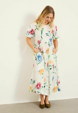 Floral Maxikleid mit kurzen Puffärmeln, weißer Hintergrund, mit farbenfrohen Blumenmustern in Pink, Blau und Gelb, mit Seitentaschen.