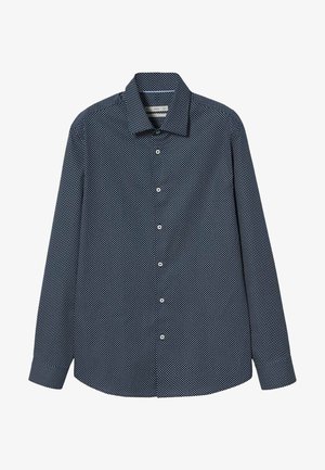 Chemise bleu marine à manches longues avec motifs géométriques blancs en points et col classique, posée à plat sur un fond blanc.