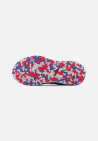Multicolored shoe sole with a textured surface featuring red, blue, and white patterns. The bottom has a solid black edge.