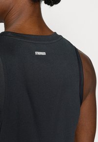 Μαύρο αθλητικό φανελάκι με ριμπ λαιμόκοψη· διαθέτει το κείμενο «STRONGER» σε λευκό στο πίσω μέρος, λεία υφή και μαν sleeveless σχεδιασμό.