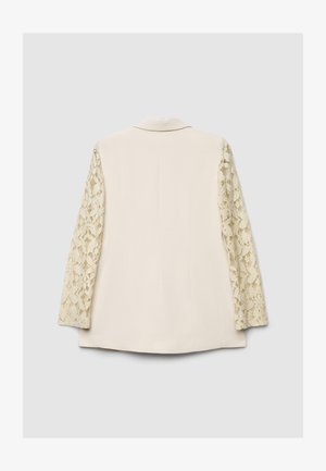 Beige blazer with long lace sleeves, textured floral pattern on lace, structured shape, single-breasted, no visible fastenings on the back.