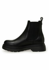 Botte Chelsea en cuir noir avec panneau latéral élastique, semelle épaisse striée et languette à l'arrière, vue de profil.