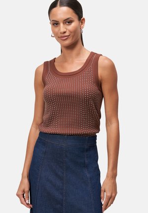 Brown ribbed tank top with white dot pattern, round neckline, wide straps, paired with a dark denim skirt featuring a straight cut.