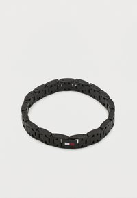 Βραχιόλι από μαύρο μέταλλο με ορθογώνιους κρίκους και μικρό ορθογώνιο λογότυπο με λευκό, κόκκινο και μπλε χρώμα.