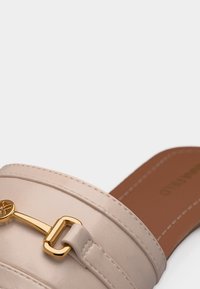 Sandale à glissière en cuir beige avec détail de boucle en métal doré sur une large bride et semelle intérieure cousue marron.