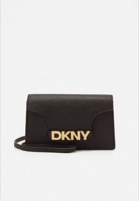 Melna sintētiskā soma pāri plecam ar pārklājuma vāciņu, zelta "DKNY" logotipu, fakturētu virsmu un regulējamu siksnu. Kompakta taisnstūra forma.