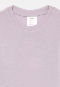 Licht lavendelkleurig merinowollen t-shirt met een ronde halslijn en een zachte textuur, voorzien van een label in de nek met maat- en verzorgingsinformatie.