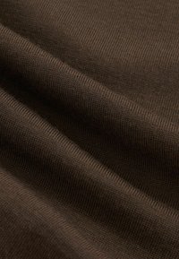 Braun gestrickter Stoff mit feiner gerippter Textur, gezeigt in sanften Falten, die die Dehnbarkeit und Webdetails hervorheben.