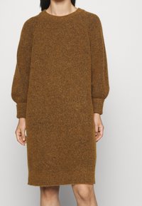 Brun ullblandad klänning med avslappnad passform, långa puffärmar och rund halsringning. Mjuk, strukturerad tyg med knä-lång skärning.