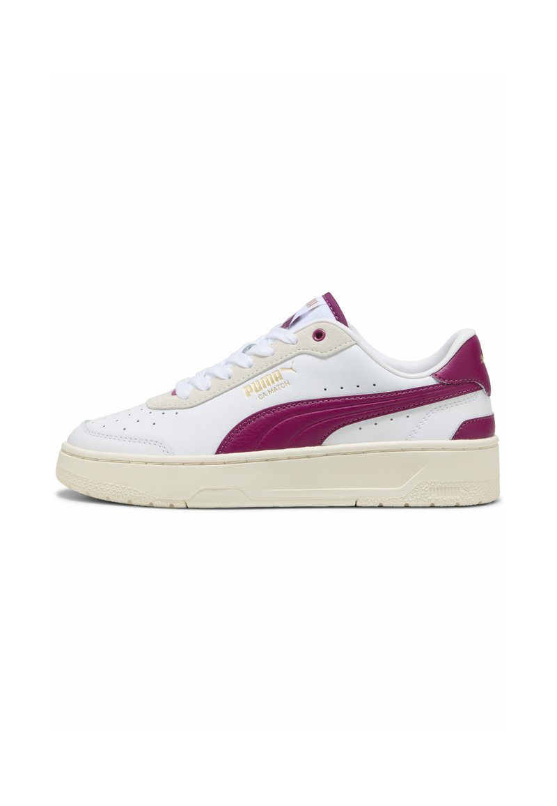 Zapatillas de piel blanca con acentos en rosa intenso, punta redondeada y suela de goma texturizada. Presenta el logo de Puma en dorado en un lado.