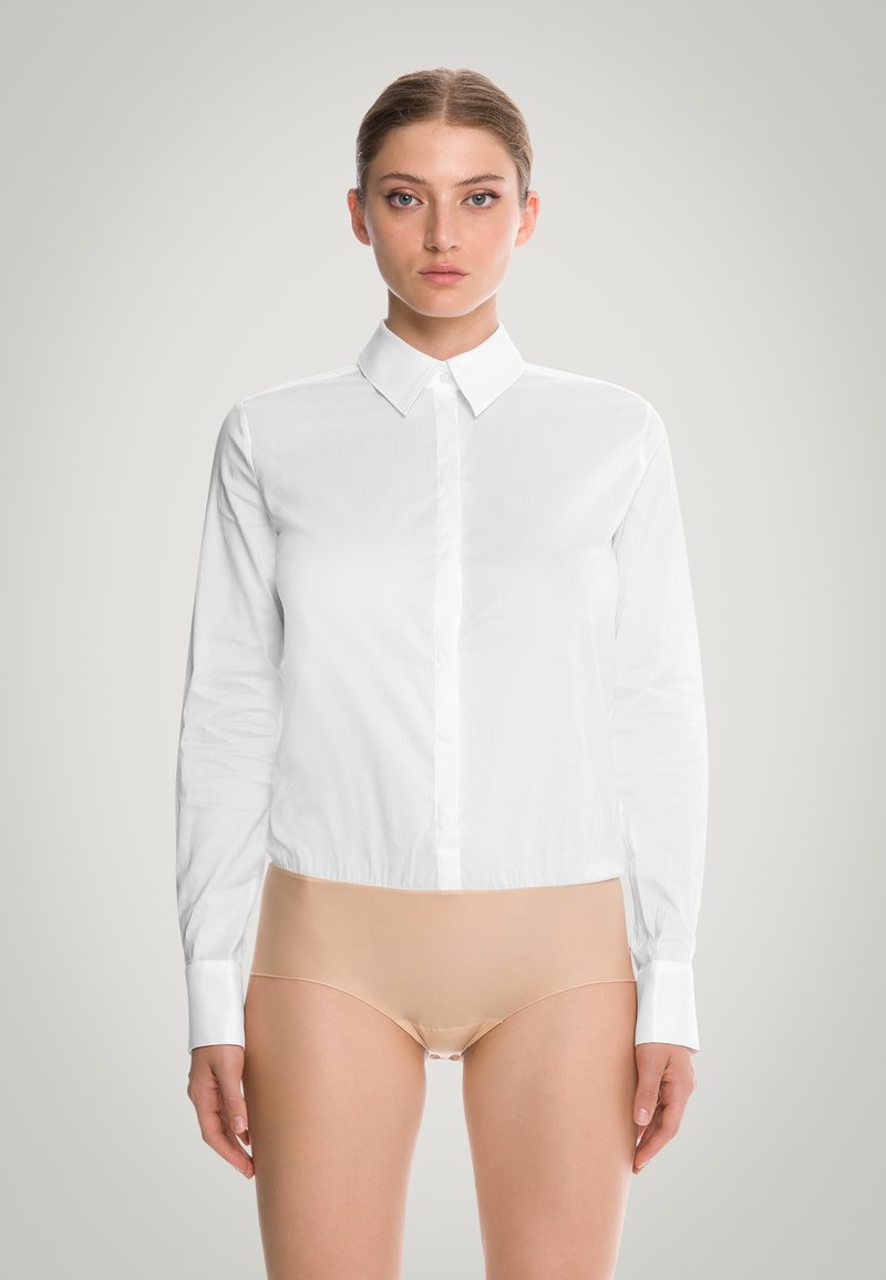 Camicia bianca a maniche lunghe realizzata in tessuto liscio, con colletto classico, chiusura con bottoni sul davanti e polsini slim.