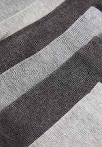Tela a rayas en tonos gris y negro de diferentes anchos, con una textura suave y un tejido fino, destacando los tonos contrastantes de gris.