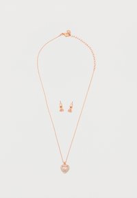 Κολιέ ροζ χρυσού με μενταγιόν σε σχήμα καρδιάς με ροζ πολύτιμο λίθο και ταιριαστά σκουλαρίκια με ροζ πολύτιμους λίθους σε λευκό φόντο.