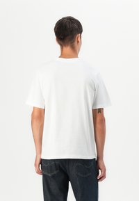 Effen wit katoenen T-shirt met korte mouwen, ronde halslijn en een relaxte pasvorm. Draagt met donkere denim jeans, met een minimalistisch ontwerp.
