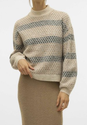 Pull en maille beige et gris à motif avec manches longues, associé à une jupe en maille texturée de couleur camel, porté par une personne debout.