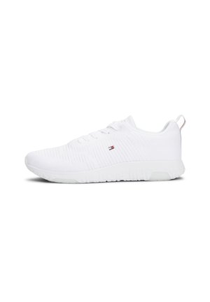 White low-top athletic sneaker with knit upper, laces, and small flag logo on side, shown in right profile on white background.