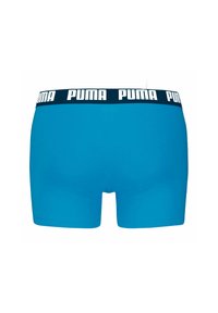 Couleur blu scuro, pantaloni boxer realizzati in tessuto elasticizzato con una cintura inlogo PUMA bianco e nero. Tessuto liscio, design aderente, lunghezza fino a metà coscia.