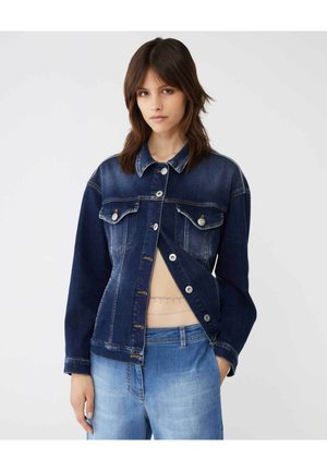 Giacca in denim blu scuro con chiusura a bottone, due tasche sul petto e colletto aperto. Il tessuto presenta leggere scoloriture in varie zone.