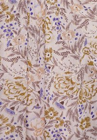 Tecido floral com um fundo rosa claro, adornado com flores douradas, castanhas e azuis. Folhas delicadas e detalhes dourados por todo o design.