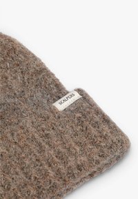 Sombrero de lana en marrón texturizado con un patrón tejido y una etiqueta blanca cosida que dice "SCALPERS" en el lateral.