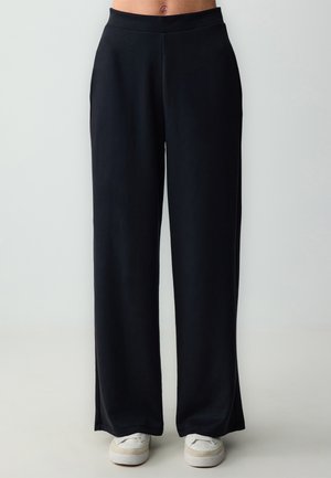 Zwarte wijde broek met een gladde textuur en elastische tailleband, met een rechte pasvorm en een lengte die tot op de grond valt.