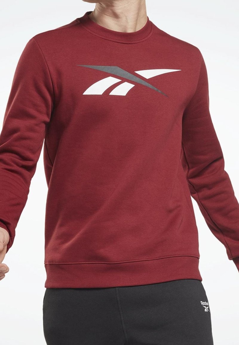 Sweatshirt bordeaux à col rond, manches longues, avec un motif graphique blanc. Comprend des poignets et un ourlet côtelés pour plus de texture.