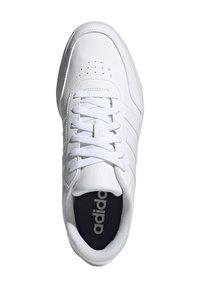 White athletic shoe with a smooth leather upper, round toe, lace closure, perforations on the toe, and “adidas” branding on the tongue.