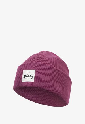 Lila gestrickte Mütze mit umgeschlagenem Bündchen und einem quadratischen weißen Etikett mit dem Markennamen. Die Textur ist gerippt und glatt.