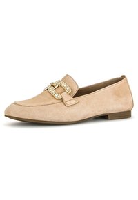 Mocassin en daim beige avec un talon plat, présentant une boucle dorée décorative et une texture lisse. Bout rond et détails de couture minimalistes.