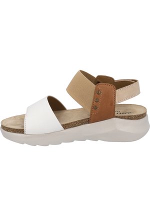 Sandales blanches et beiges avec des sangles élastiques, une semelle intérieure rembourrée et une semelle extérieure en caoutchouc texturé marron. Présentent une empeigne en cuir lisse et en synthétique.