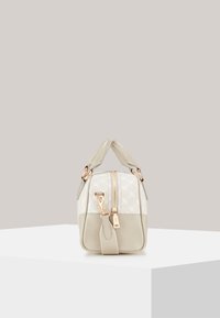 Beige leren handtas met een textuur crème paneel, gouden hardware, bovenhandvatten, en een ritssluiting. Opvallende stiksels en subtiele logo-detail.