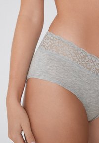Helle graue Baumwollunterhose mit einem Spitzenbund im floralen Muster. Angenehme Textur, mittlere Leibhöhe und filigrane Spitzenverzierung.