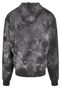 Hoodie u tamno sivoj boji s tie-dye uzorkom. Ima duge rukave i rebraste manšete i donji rub. Mekana tekstura tkanine.