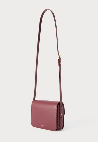 Ορθογώνια τσάντα ώμου από δέρμα σε μπορντό χρώμα με μακρύ ρυθμιζόμενο λουρί και κλείσιμο με καπάκι πάνω σε λευκό φόντο.