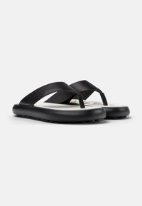 Black flip-flop sandals with textured straps, thick cushioned soles, and a white footbed. Features streamlined design for comfort.