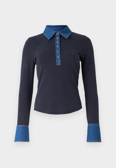 Marinblå långärmad polo tröja har en denimkrage, knapplist med dekorativ sömnad och denimdetaljer vid ärmsluten.